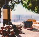 A full Red Wine glass on a table with a scenic view to the Mediterranean sea