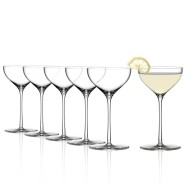 A set of elegant cocktail glasses with five empty glasses aligned and one glass filled with a light-colored cocktail, garnished with a slice of lemon.