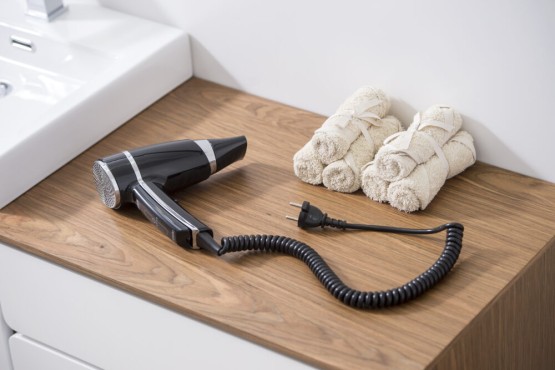 Sort hotelhårtørrer i hotelbadeværelset.